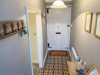 a hallway with a white door and a tile floor at Holiday Home Cherry Orchard House by Interhome in Mevagissey