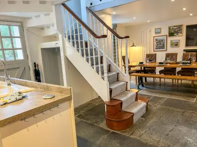a staircase in a living room with a dining room at Holiday Home Cherry Orchard House by Interhome in Mevagissey