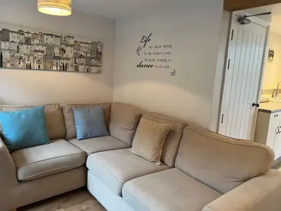 a living room with a brown couch and blue pillows at Holiday Home Cherry Orchard House by Interhome in Mevagissey