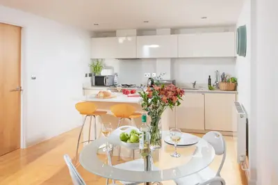 a kitchen and dining room with a glass table and chairs at 22 Zinc in Newquay