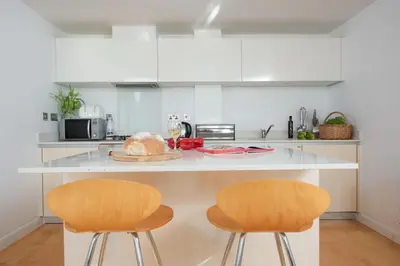 a kitchen with two chairs and a counter top at 22 Zinc in Newquay