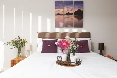 a bed with a tray with flowers on it at 22 Zinc in Newquay