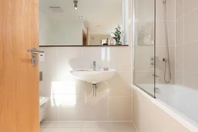 a white bathroom with a sink and a shower at 22 Zinc in Newquay