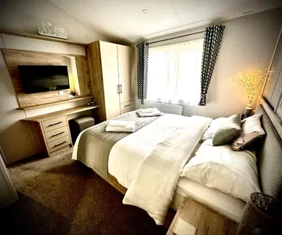 a bedroom with a large bed and a window at C-Scape Lodge in Newquay