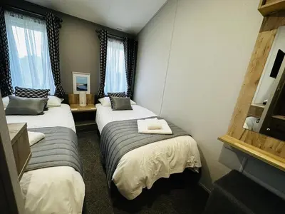 a hotel room with two beds and two windows at C-Scape Lodge in Newquay
