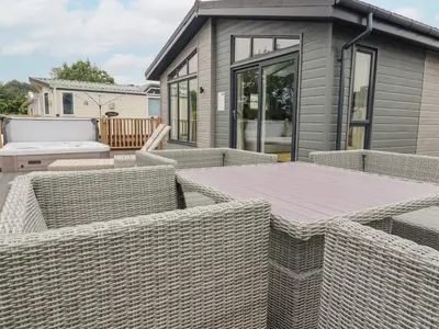 a backyard with wicker chairs and a tiny house at Mordros Lodge in Redruth