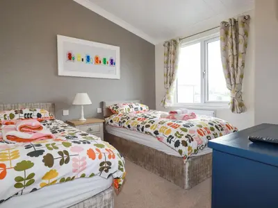 a bedroom with two beds and a window at Mordros Lodge in Redruth