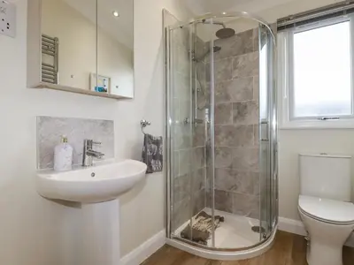 a bathroom with a shower and a sink and a toilet at Mordros Lodge in Redruth