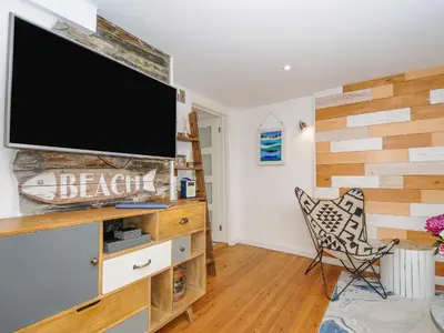 a living room with a flat screen tv on a wall at Salty Sea Dog in Tintagel