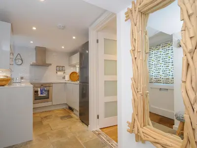 a kitchen with a mirror on the wall at Salty Sea Dog in Tintagel