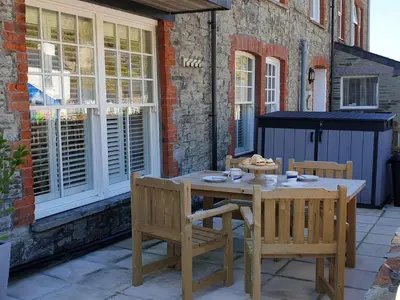 a wooden table and chairs on a patio at Salty Sea Dog in Tintagel