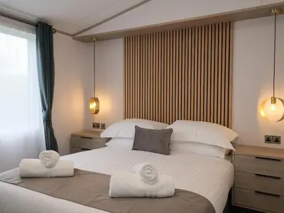 a bedroom with a large bed with towels on it at Penmarlam Lodge Retreat 18 in Fowey