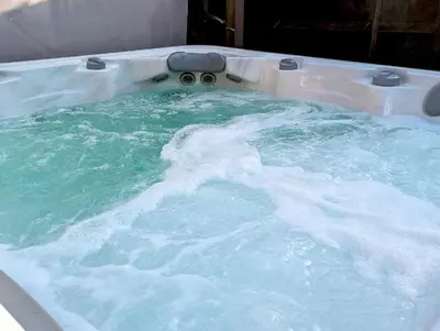 a bath tub filled with blue water in a bath room at Penmarlam Lodge Retreat 18 in Fowey