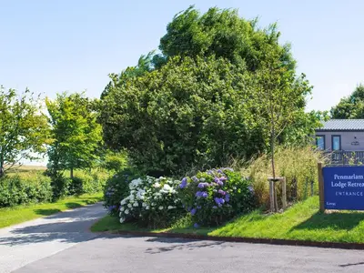 a sign for a house with flowers on the side of a road at Penmarlam Lodge Retreat 18 in Fowey