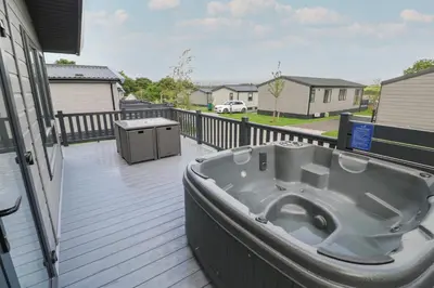 a bath tub sitting on the deck of a house at Penmarlam Lodge Retreat 18 in Fowey