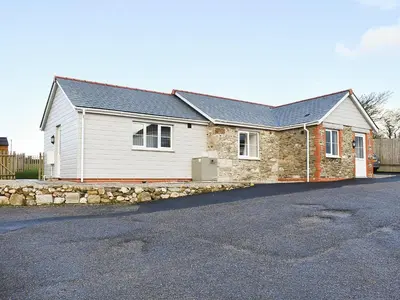 a brick and stone house with a driveway at Four Burrows Bungalow in Chacewater