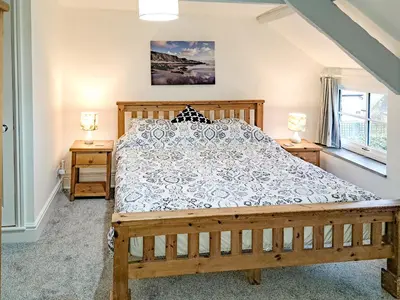 a bedroom with a wooden bed and two night stands at Appleloft in Saint Gennys