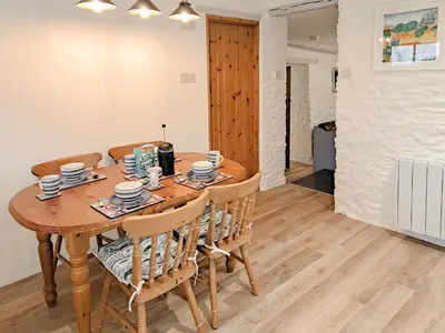 a dining room with a wooden table and chairs at Appleloft in Saint Gennys