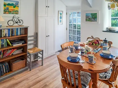 a dining room with a wooden table and chairs at Appleloft in Saint Gennys