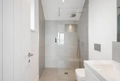 a bathroom with a shower and a toilet and a sink at Shore Edge in Portreath