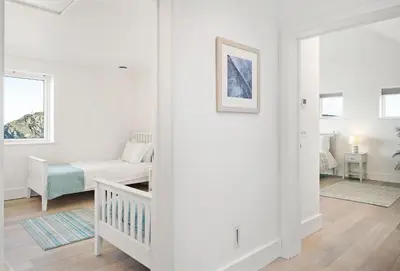 a white living room with a crib and a couch at Shore Edge in Portreath