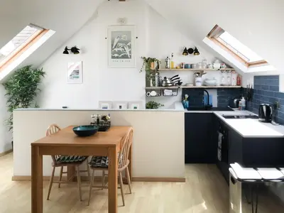 a kitchen with a wooden table and a small kitchen with black counters at Little Fursdon Apartment in Liskeard