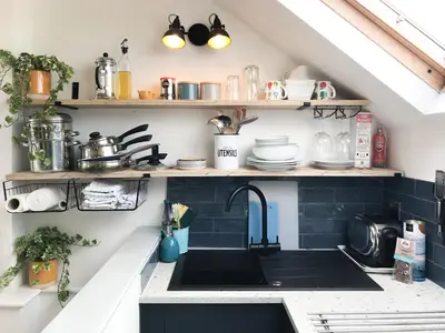 a kitchen with a sink and shelves with dishes at Little Fursdon Apartment in Liskeard