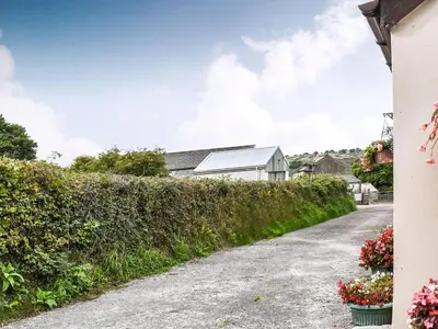 a driveway with a hedge next to a house at Anneth Lowen in Perranwell