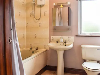 a bathroom with a sink and a toilet and a tub at Anneth Lowen in Perranwell