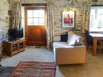 a living room with a couch and a television at Turneys Cottage - Uk42115 in Bodmin