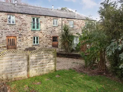 a brick house with a fence in front of it at Turneys Cottage - Uk42115 in Bodmin