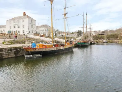 two boats are docked in a body of water at The Old Smokehouse in St Austell