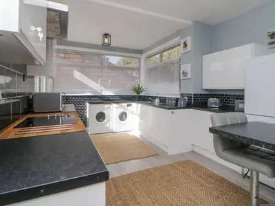 a kitchen with a washer and dryer in it at Raven Cottage in Torpoint