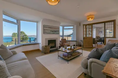 a living room with two couches and a fireplace at Beachcroft in St Ives