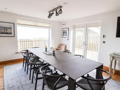 a dining room with a table and chairs at Beachcroft in St Ives