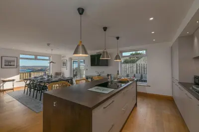 a kitchen and dining room with a view of the ocean at Beachcroft in St Ives
