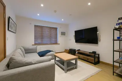 a living room with a couch and a flat screen tv at Beachcroft in St Ives