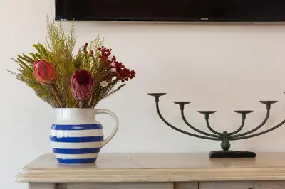 a blue and white vase with flowers on a table at Beachcroft in St Ives