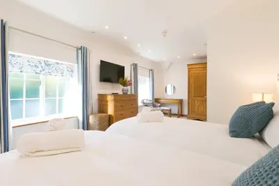 a bedroom with two beds and a window at Beachcroft in St Ives