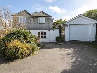 a house with a white garage and a driveway at Beachcroft in St Ives