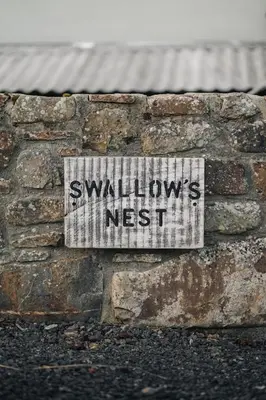 a sign on the side of a brick wall at Swallows Nest at Widemouth Bay - 2 bedroom cottage in Bude