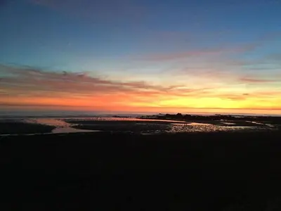 a sunset on the beach with the ocean at Swallows Nest at Widemouth Bay - 2 bedroom cottage in Bude