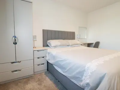 a bedroom with a white bed and a desk at 6B The Mews in Padstow
