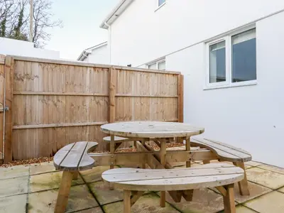 a picnic table and two benches on a patio at 6B The Mews in Padstow