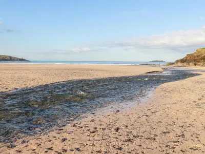 a sandy beach with a stream of water at 6B The Mews in Padstow