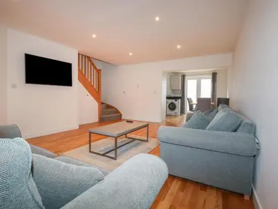 a living room with two couches and a table at 6A The Mews in Padstow