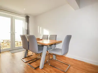 a dining room with a wooden table and chairs at 6A The Mews in Padstow