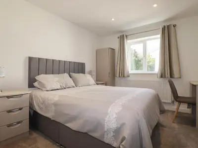 a bedroom with a bed and a desk and a window at 6A The Mews in Padstow