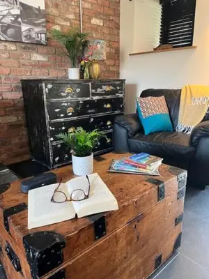 a living room with a wooden coffee table with glasses on it at The Stable at Widemouth Bay - 2 bedroom cottage in Poundstock