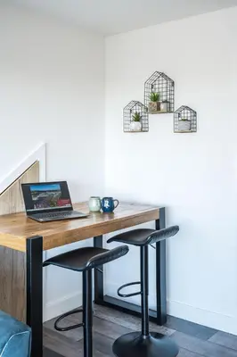 a desk with a laptop and two bar stools at Porthleven View in Porthleven